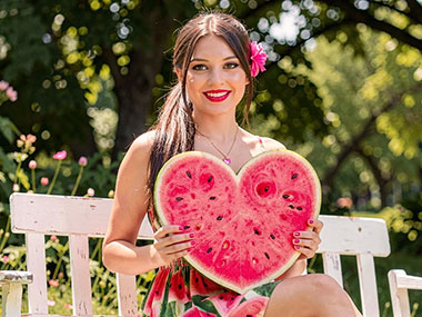 Frau mit einer großen Melone in Form eines saftigen Herzes